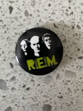 R.E.M. Band Logo Pin - Black with Lime Green Text.  1”